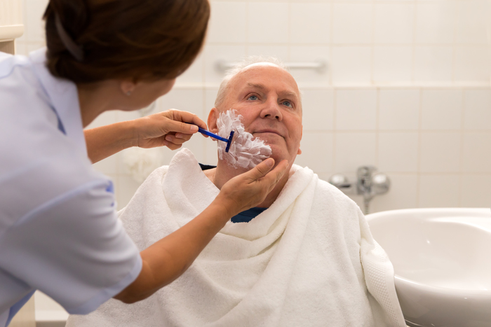 Personal hygiene – home caregiver with senior man in bathroom Personal hygiene – home caregiver with senior man in bathroom